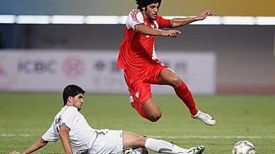 Gulom Urunov of Uzbekistan slides to tackle Abdullah Mousa of the UAE in a pool match yesterday.