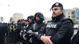 Police stand guard during a protest in Amman. Three personnel were killed in the raid in the east of the capital. Getty Images