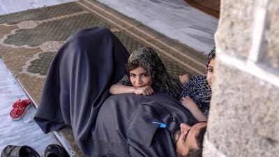 A Palestinian man rests with his daughters in Al Omari mosque. EPA