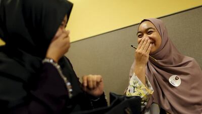 Izzaty, right, 26, with her chaperone Fateha, 26, laugh together at Halal Speed Dating, a matchmaking event, in Kuala Lumpur, Malaysia. Olivia Harris / Reuters