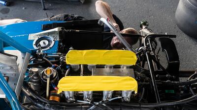 Working on the wheel hub and brake assembly of a Maki F101-C in the parking and paddock area