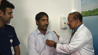 A doctor from Lifecare Hospital checks the health of a worker in Mussaffah after inaugurating the mobile clinics initiative. Ravindranath K / The National