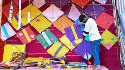 A worker arranges kites on display for sale at a shop ahead of the Makar Sankranti kite festival in Hyderabad on January 7, 2025. (Photo by NOAH SEELAM / AFP)