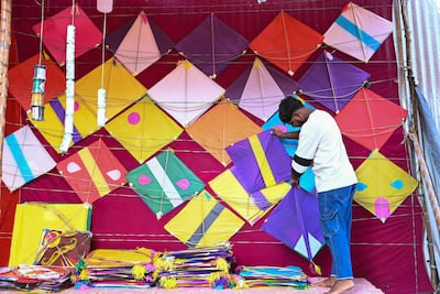 A worker arranges kites on display for sale at a shop ahead of the Makar Sankranti kite festival in Hyderabad. AFP
