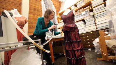 Kate Sahmel, a textile conservator, steams the engagement dress of character Mary. AP