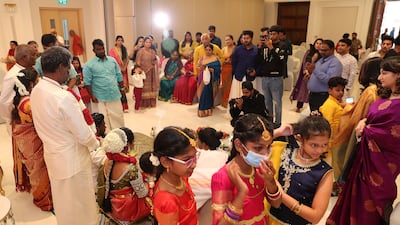 Well-wishers gather around the bridal couple in the community hall on the first floor of the temple