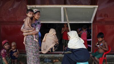 Rohingya women and their children wait to receive treatment at a makeshift clinic in the Thet Kae Pyin camp for internally displaced people in Sittwe, Rakhine state.