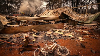 A burnt bicycle lies on the ground in front of a house recently destroyed by bushfires on the outskirts of the town of Bargo. Getty Images