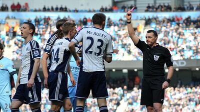 West Bromwich Albion's Gareth McAuley, second right, is errantly shown a red card by referee Neil Swarbrick, right, in Saturday's Premier League match against Manchester City. Steve Parkin / AFP