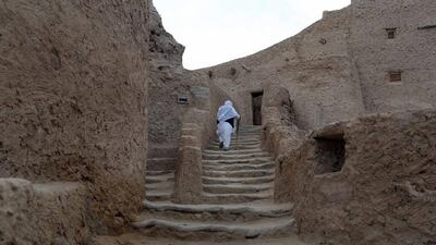 Sheikh Abdulla, a blind man, uses his stick to climb to a mosque inside the old city, Shali, where he works as an Imam.