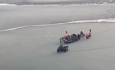 Migrants carrying a boat across the beach as French police intercept them. Photo: UK Home Office