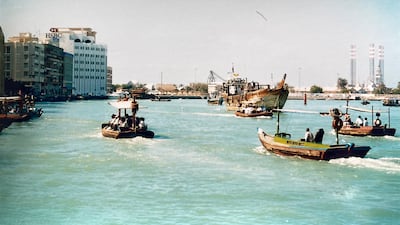 A busy day on Dubai Creek in the 1980s as abras and dhows chug across the water. The HSBC building can be seen on the left.