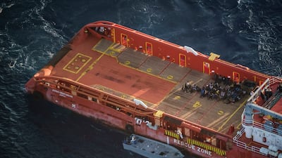 Migrants sit on the deck of the Italian supply vessel ‘Asso Ventinove’ after they were rescued from an unseaworthy boat drifting in the Mediterranean near the Bouri oilfields, north of Libya.