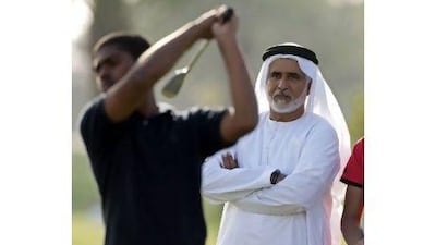 Seven-time UAE national champion Ismail Sharif, right, watches Oma Abul Kareem tee off during the event at Dubai Creek Golf and Yacht Club in Deira yesterday. Jeff Topping / The National