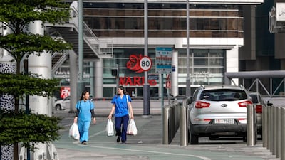 Health workers carry groceries at downtown Abu Dhabi.