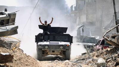 A member of the Counter-Terrorism Service (CTS) makes victory signs while advancing in the Old City of Mosul on June 30, 2017. Ahmad Al Rubaye / AFP