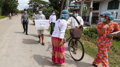 Officers and volunteers from Union Election Commission walk to collect ballots from elderly people who make an early voting on the outskirts of Yangon. AP Photo