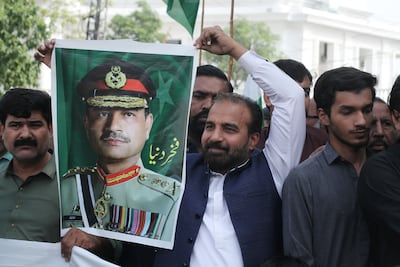 Members of a rickshaw union hold up a poster of Field Marshal Asim Munir while celebrating the US-Iran ceasefire in Lahore, Pakistan. EPA