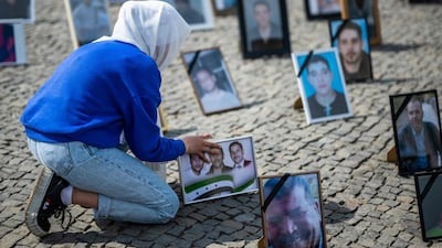 A protester places, during a demonstration in Berlin in 2022, portraits of Syrians believed to have been detained or forcibly disappeared by the Syrian government. AFP