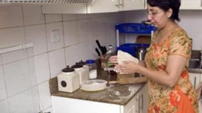 Amna Khaishgi makes a traditional Indian bread called chapatti to go along with a chicken curry she is cooking for iftar in her home in Dubai.