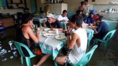 Filipinos eat inside a flooded restaurant in suburban Pasig, east of Manila yesterday.
