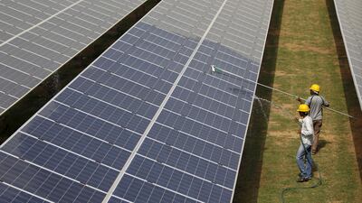 Workers clean PV panels at a solar plant in Gujarat, India. The country aims to grow its renewables sector. Reuters