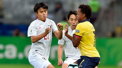 Japan's Takefusa Kubo, left, and Ecuador's Romario Ibarra vie for the ball. AFP