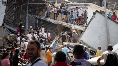 A crowd gathers at a damaged shop in Catia La Mar. EPA