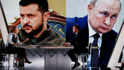 French President Emmanuel Macron is interviewed in front of pictures of Ukrainian President Volodymyr Zelenskyy and Russian President Vladimir Putin. AFP