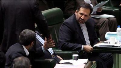 Iranian finance minister Shamseddin Hossein, who survived an impeachment vote yesterday, talks to Iranian president Mahmoud Ahmadinejad, left, in parliament.