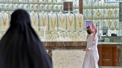 A Saudi man, wearing a protective mask, walks past a jewellery shop in Riyadh. Saudi Arabia's non-oil private sector economy improved slightly in April, but remained in contraction territory. AFP