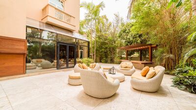The outdoor space with barbecue and acacia tree countertop in the background. Courtesy LuxuryProperty.com