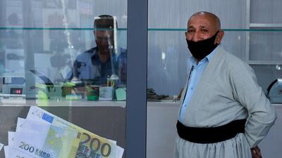 An Iraqi man, wearing a protective mask waits at a money exchange office in Sulaimaniyah city. AFP