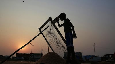 Indian boy Rajnder, 13, sorts dried fish at a fishing colony as the sun sets in Mumbai, India, on November 10, 2014. Rajinder goes to school in the morning and spends the evenings helping his parents in their fishing business. Rafiq Maqbool / AP Photo