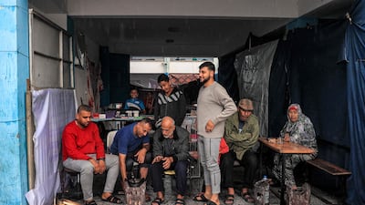People shelter from the rain in a hall at an UNRWA-run school in Rafah, as winter moves in. AFP