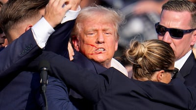 Republican presidential candidate former president Donald Trump is helped off the stage by US Secret Service agents at a campaign event in Butler, Pennsylvania, on Saturday, July 13, 2024. AP