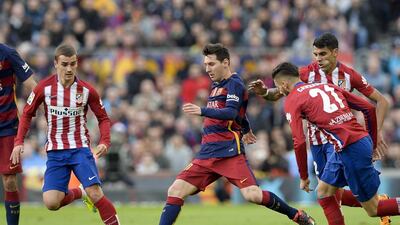 Barcelona's Lionel Messi, centre, vies with Atletico Madrid's Antoine Griezmann, left, and Augusto Fernandez during the Spanish league match at the Camp Nou stadium in Barcelona on January 30, 2016. AFP PHOTO/ JOSEP LAGO