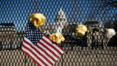 Flowers are placed on a fence, a week after a pro-Trump mob broke into and took over the Capitol, in memory of slain Capitol Police Officer Brian Sicknick in Washington, DC. AFP
