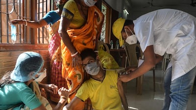 A health worker inoculates a disabled boy in Siliguri, north-east India. AFP