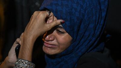 A local resident reacts as she speaks on the phone during a rescue operation at the site where an advertisement billboard collapsed at a petrol station following a dust storm in Mumbai on May 13, 2024. (Photo by Punit PARANJPE / AFP)