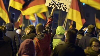 A Pegida supporter holds a banner advocating against "Islamic terror" at a protest in Cologne on Monday. (Martin Meissner/AP)
