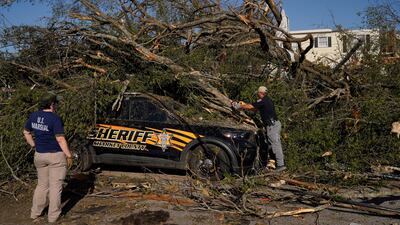 A Mississippi law enforcement officer tries to free a trapped police vehicle after tornadoes swept across the southern US state. Reuters