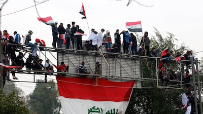 Supporters of Moqtada Al Sadr chant slogans and carry the Iraqi national flag during a demonstration. EPA