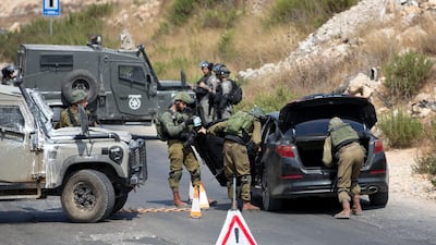 Israeli forces search of Palestinian vehicle near the area of an attack, west of the West Bank city of Ramallah. AP