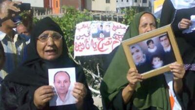 Egyptian relatives holding photographs of loved ones protest outside the court.