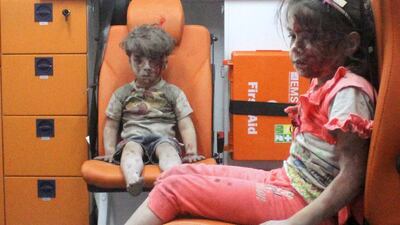 Five-year-old Omran Daqneesh, with bloodied face, sits with his sister inside an ambulance after they were rescued following an airstrike in the rebel-held al-Qaterji neighbourhood of Aleppo, Syria August 17, 2016. Mahmoud Rslan / Reuters
