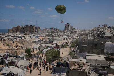 Palestinians rush to collect humanitarian aid airdropped by parachute into Gaza city. AP