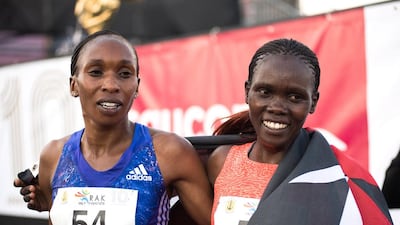 Cynthia Limo, who finished first the in the women’s race takes photos with runner-up Gladys Cherono.