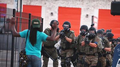 Police in Ferguson, Missouri, maintain order after several nights of confrontation following the shooting death of black teenager Michael Brown who was killed last Saturday in the St Louis suburb. Yesterday, 32 arrests were made after protests turned into rioting and looting. Scott Olson / Getty Images / AFP