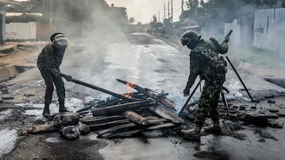 Kenyan police officers remove burning barricades from a road in Nanyuki. AFP